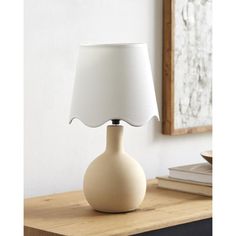 a white lamp sitting on top of a wooden table