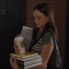 a woman holding several books in her hands