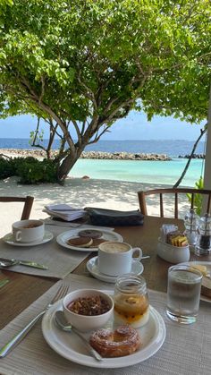 the table is set for breakfast on the beach