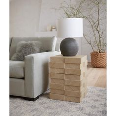 a lamp sitting on top of a stack of boxes next to a chair and couch