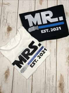 two t - shirts with the words mr and mrs printed on them are laying next to each other