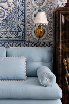 a blue couch sitting in front of a lamp