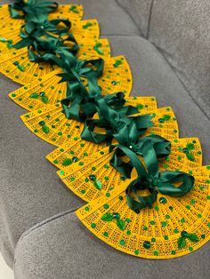 yellow lace with green ribbons on the back of a gray couch in a living room