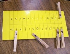 several clothes pins are placed on top of a wooden board that has letters and numbers