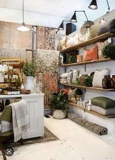 a room filled with lots of different types of pillows and blankets on shelving units