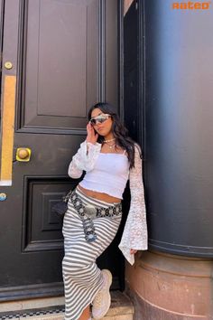 A girl wearing a black and white stripped maxi skirt with a white lace crop top with sleeves wearing sunglasses and a black and silver boho belt Y2k Outfits With Belts, Trends Summer 2023, Belt Y2k, Boho Y2k