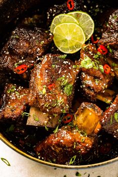 a close up of food in a pan with limes