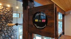 a clock on the side of a wall in a room with wood flooring and stone walls