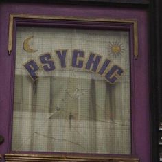 a purple door with the word psychic painted on it's side and an open window