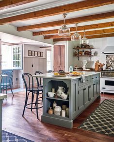 a kitchen with an island in the middle of it and lots of chairs around it