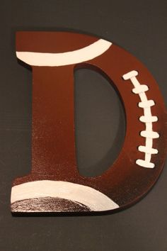 the letter d is made out of wood and has a football on it's side