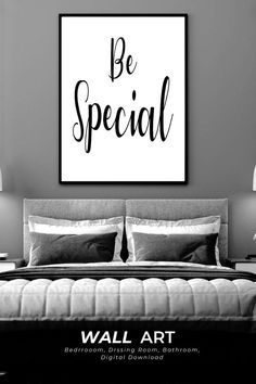 a black and white poster with the words be special on it, above a bed