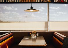 a table with some food on it in front of a window that looks out onto the beach