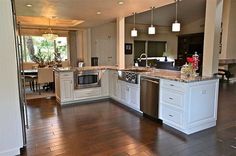 a large kitchen with white cabinets and stainless steel appliances