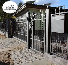 an iron gate is on the side of a house with a sign above it that says t v - da metal