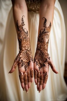 two hands with henna tattoos on them