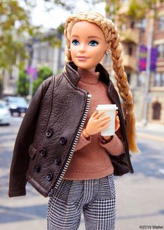 a barbie doll holding a coffee cup and wearing a brown jacket with braids on her head