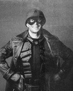 black and white photograph of a man wearing a leather jacket with his hands on his hips