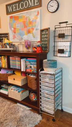 a welcome sign is hanging on the wall above a bookcase filled with children's books