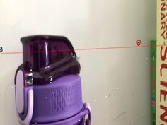 a purple blender sitting on top of a white wall