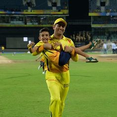 two men in yellow uniforms walking on a baseball field with one holding the other's arm