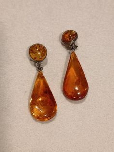 Vintage amber on silver earrings. Made in Germany in the 1950s to 1970s. These earrings comprise an amber  teardrop hanging from a round piece of amber set in silver. The proportions are very pleasing. Amber jewellery was often sold as souvenirs 50 years ago: I bought some myself at this time. The earrings have a soft clip, and are comfortable to wear. The earrings are 5.5 cm long (drop 3.8 cm). They are in perfect condition. Amber Earrings, 50 Years Ago, Dec 12, Amber Jewelry, Vintage Jewellery, Vintage Earrings, 50 Years, Sterling Silver Earrings, Jewelry Earrings Dangle