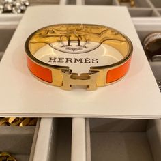 Hermes Clic H Bracelet - Orange Fruit / Gold Gorgeous Hermes Classic Clic H Bracelet. A Must Have For Every Fashionista! Narrow Bracelet In Enamel With Gold-Plated Hardware. In Their Staple Orange Color. Brand New. Never Been Used. But. No Box Included. Comes Fully Sanitized From A Smoke Free Home. Modern Orange Bangle Bracelets, Elegant Orange Bangle Jewelry, Hermes Clic H Bracelet, Hermes Bangle, Bracelets Outfit, H Bracelet, Hermes Bracelet, Hermes Orange, Expensive Gifts