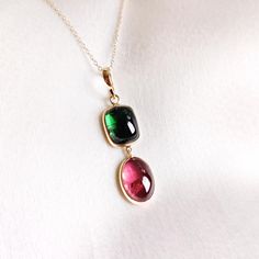 This stunning pendant is set in 14K Solid Yellow Gold with Natural Pink Tourmaline with utmost precision. It is an unique gemstone pendant for nearly every occasion and is completely hassle-free jewelry. ITEM DETAILS * Gem: Pink Tourmaline * Gem Size: 9x12mm * Gem Shape: Oval cab * Gem: Green Tourmaline * Gem Size: 8.5x10.5mm * Gem Shape: Cushion cab * Gem Weight: 9.73 carats * Gold Purity: 14KT  * Gold Weight: 0.938 gram * Total Weight of the Pendant: 2.884 gram ✔️The Gold purity is guaranteed Handmade Jewelry Box, Tourmaline Pendant, Tourmaline Jewelry, Bezel Pendant, Jewelry Christmas, Birthstone Pendant, October Birthstone, Yellow Gold Pendants, Unique Gemstones