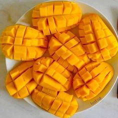 a white plate topped with cut up mangoes