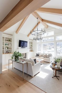 a living room filled with furniture and a flat screen tv mounted on the wall next to a fireplace