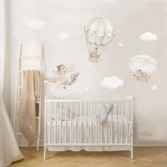 a baby's room with a crib and wall decals in the shape of hot air balloons