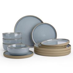 a set of blue dishes and plates with beige rims on the sides, in front of