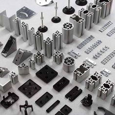 various metal parts are arranged on a white surface, including screwdrivers and other tools