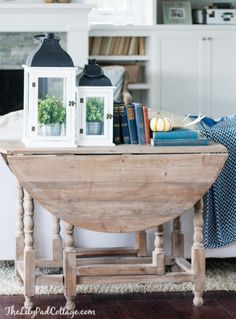 a wooden table topped with books next to a fireplace