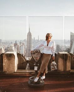 a woman standing on top of a tall building