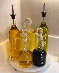 three bottles of different types of liquid on a white tray in a bathroom with a mirror behind them