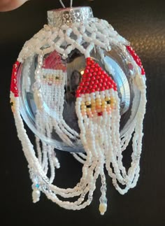 a christmas ornament made out of beads and beadwork with a santa clause on it