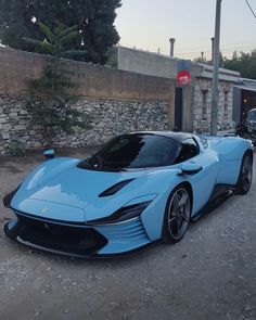 a blue sports car parked in front of a building