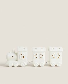 three small white toy trains sitting next to each other