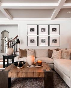 a living room filled with lots of furniture and pictures on the wall above it's coffee table