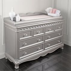 a baby's crib in the corner of a room with white walls and wood floors