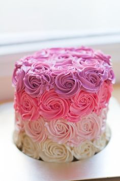 a cake with pink and white frosting roses on it