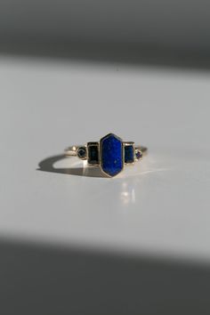 Art deco inspired ring with lapis lazuli and blue sapphires. Lapis Lazuli is inlaid into the elongated hexagon, measuring 9.5mm x 5mm. Accent blue sapphires are approximately .30 total carat worth. Millimeter measurement from end to end is 15mm. The setting is hand-carved and cast in 14k yellow gold. The band is 1.75mm thick. Please leave a note at checkout with your preferred size. All gems and rocks are nuanced and color, please know that your ring will be very similar to the pictured ring, bu Art Deco Style Jewelry, Minimalist Sapphire Engagement Ring, Lapis Lazuli Jewellery, Lapis Wedding Ring, Lapis Lazuli Wedding Ring, Lapis Engagement Ring, Blue Gold Ring, Lapis Lazuli Mirror, Antique Art Deco Engagement Rings