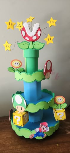 a paper mario birthday cake on top of a wooden table next to a wall with stars