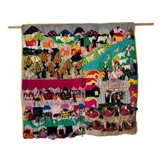 a multicolored quilt hanging on a clothes line with shoes and other items in it