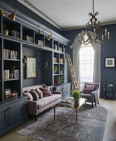 a living room filled with furniture and a chandelier hanging from the ceiling over a window