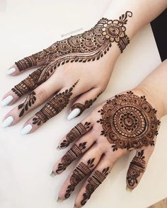 two hands with henna designs on them