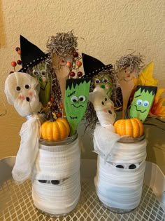 three decorated jars with halloween decorations in them