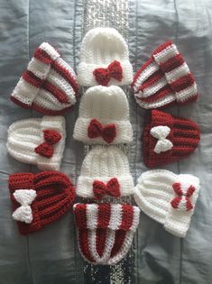 several knitted hats and mittens laid out in a circle on top of a bed