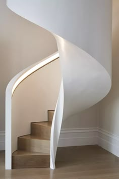 a white spiral staircase in an empty room